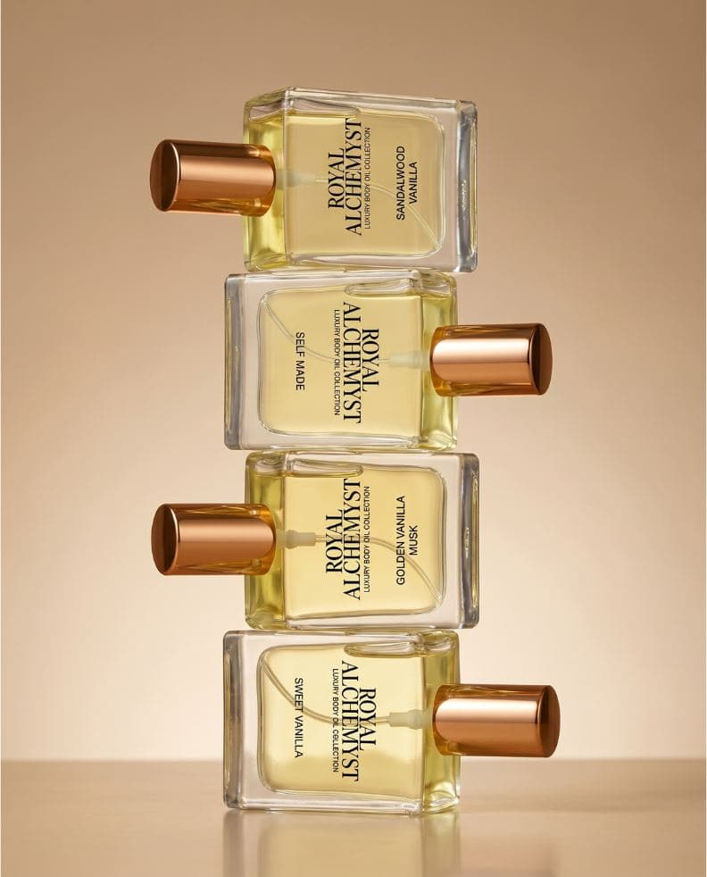 Four Royal Alchemyst travel-size body oil bottles stacked in a column