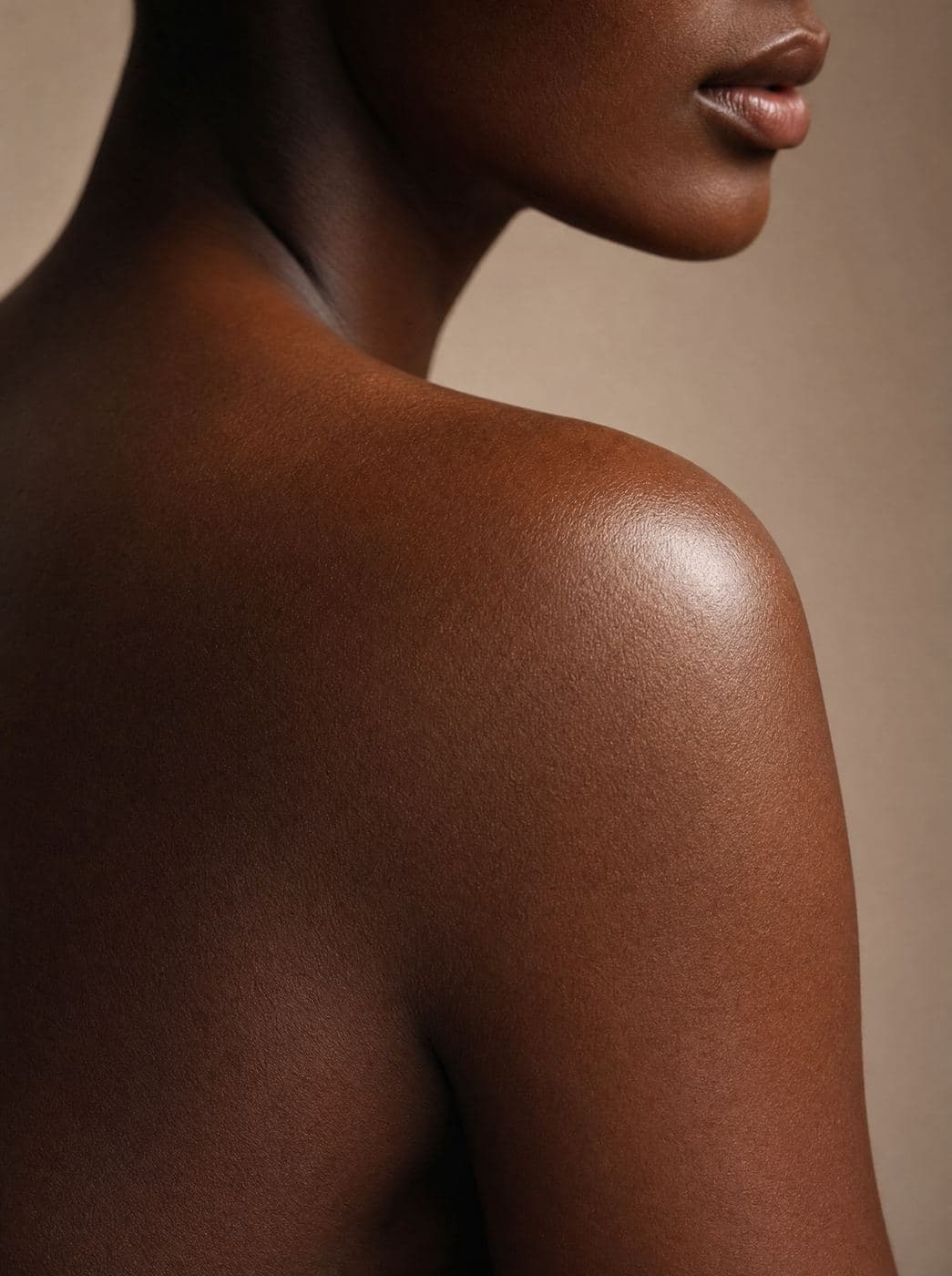 Close-up of a shoulder with glowing, oiled skin